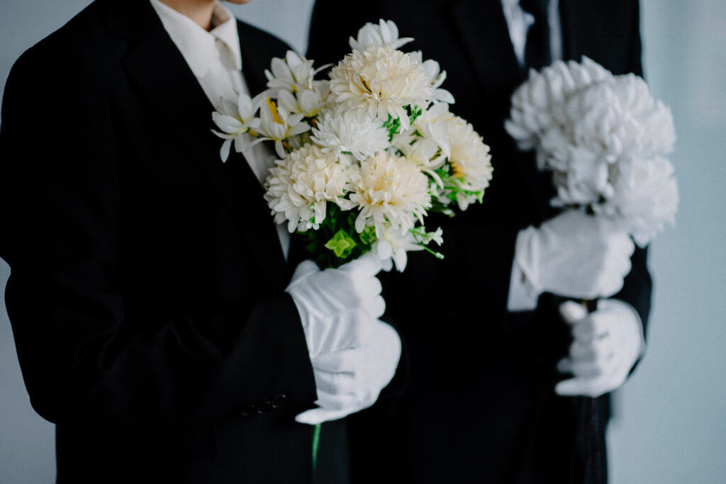 Mourning,Man,And,Woman,With,Flowers,At,Funeral